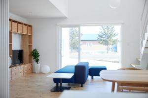 a living room with a blue couch and a table at Nippou no Ie Kamishihoro - Vacation STAY 58990v in Kami-shihoro