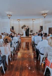 a bride and groom walking down the aisle in a wedding ceremony at The Gathering Place in Salina