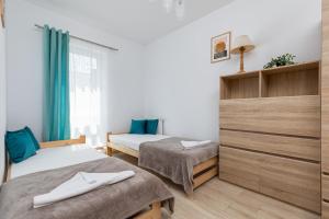 a room with two beds and a window at Nad Zalewem - Familijny Apartament z Widokiem na Zatokę by Renters in Dziwnówek