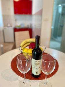 una mesa con dos copas de vino y un bol de fruta en Apartments Marina, en Budva