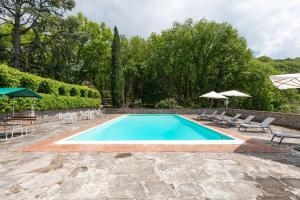 - une piscine avec des chaises et des parasols dans la cour dans l'établissement Casa nel cuore del Chianti, à Gaiole in Chianti