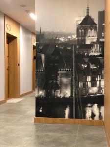 a hallway with a painting of a city at Apartament Bastion Wałowa in Gdańsk