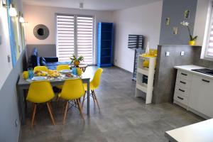 a kitchen and dining room with a table and yellow chairs at Laba in Jastrzębia Góra