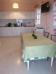 a kitchen with a table with a green table cloth on it at AURORA MANSION (Crystal Rose) in Kornáta