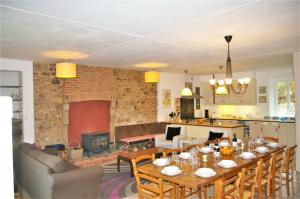 a kitchen and a dining room with a table and a fireplace at Le Cerisier in Saint-Symphorien-de-Marmagne