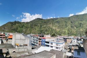 un groupe de bâtiments devant une montagne dans l'établissement GIGAHOUSE, à Baños