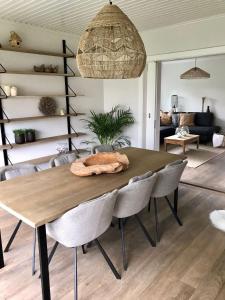 a dining room table and chairs in a living room at De Bijenkorf in Damme