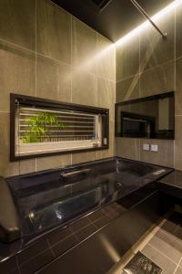 La salle de bains est pourvue d'une baignoire et d'une fenêtre. dans l'établissement J1 wellness - Vacation STAY 62605v, à Tateyama