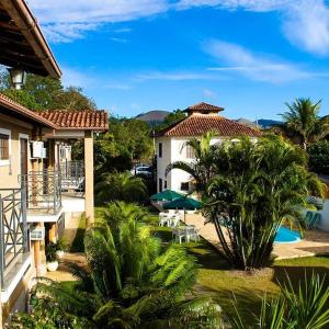 - une vue sur un complexe avec une piscine et des palmiers dans l'établissement Pousada Alto da Colina, à Conservatória