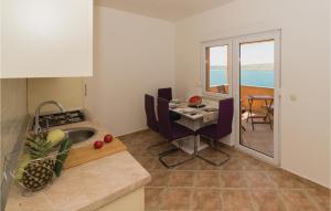 a kitchen with a table and a dining room with the ocean at 2 Bedroom Beautiful Apartment In Vlasici in Vlašići