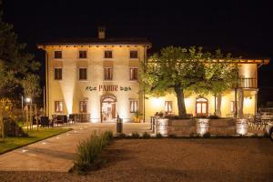 a large white building with a tree in front of it at Hotel & Restaurant Pahor in Doberdò del Lago