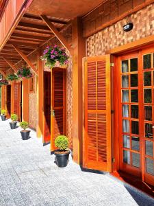 un edificio con puertas de madera y macetas. en Pousada Aconchego na Montanha en Campos do Jordão