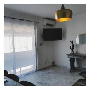 a room with a television and a table and chairs at COTE PLAGE HYPER CENTRE - Bord de mer in Le Grau-du-Roi