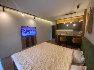 um quarto com uma cama e uma cozinha com um bar em Gomax apartman 4 em Zlatibor
