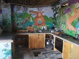 uma cozinha com um macaco pintado na parede em Be a Guest at PachaMama Community em Alcácer do Sal