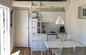 una cucina con tavolo e sedie bianchi e una scala di Beautiful Home In Hassl With Wifi a Hasslö