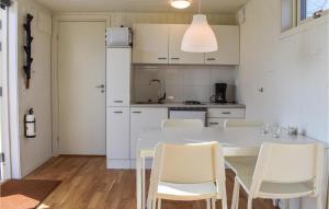 eine weiße Küche mit einem Tisch und Stühlen in der Unterkunft Beautiful Home In Hassl With Wifi in Hasslö