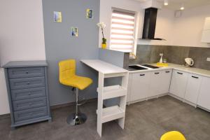 a kitchen with a desk and a yellow chair at Laba in Jastrzębia Góra