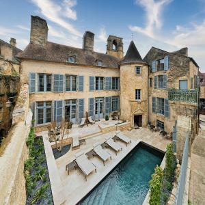 una finca con piscina frente a un edificio en LE PETIT MANOIR, en Sarlat-la-Canéda