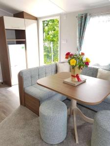 een woonkamer met een tafel en een bank bij Lake District 2021 Deluxe Static Caravan on Haven Lakeland in Flookburgh
