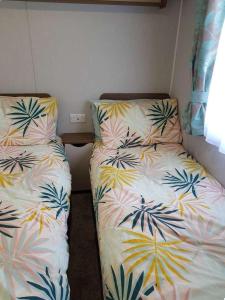 twee bedden naast elkaar in een kamer bij Lake District 2021 Deluxe Static Caravan on Haven Lakeland in Flookburgh