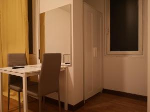 Zimmer mit einem Tisch, einem Stuhl und einem Spiegel in der Unterkunft New Life in Mestre