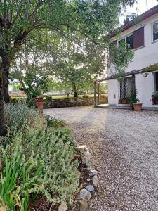 una casa con una entrada de grava frente a una casa en Agriturismo La Locandiera, en Montemerano