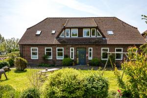 a brick house with a blue door at Lubblerhof in Fehmarn