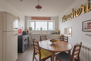 a kitchen with a table and chairs and a refrigerator at The Buoys in Dungeness