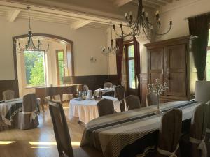 un comedor con mesas, sillas y un piano en Chateau Tout Y Fault, en Loriges