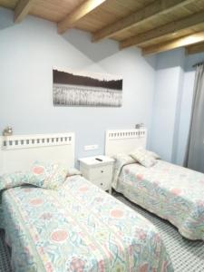 dwa łóżka w pokoju z białymi ścianami w obiekcie Casa Rural La Plata w mieście Aljucén
