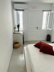 a bedroom with a white bed and a white door at Camara Homes in Andros