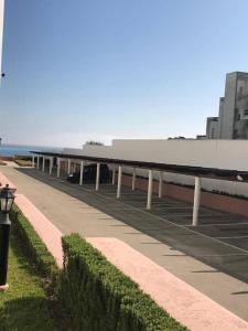 un long bâtiment avec un parking à côté de l'océan dans l'établissement Marina beach, à Fnideq