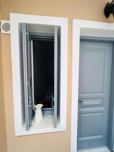 a window with a vase in it next to a door at Camara Homes in Andros