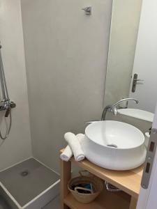 a bathroom with a white sink and a shower at Camara Homes in Andros