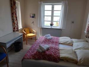 una camera da letto con un letto, una scrivania e una finestra di Det Gamle Hotel Rudkøbing a Rudkøbing