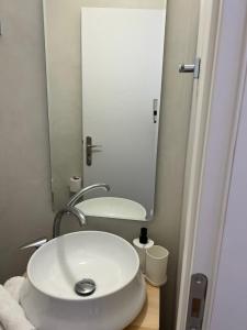 a bathroom with a white sink and a mirror at Camara Homes in Andros