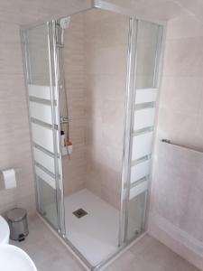 a shower with a glass door in a bathroom at La casita de Meiro in Bueu