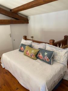 een slaapkamer met een bed met kussens erop bij Maison de 2 chambres avec piscine privee jardin amenage et wifi a Bruniquel in Bruniquel