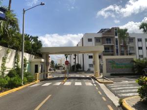 una calle vacía con un edificio con una señal de stop en Oasis Palma Real santiago, Republica Dominicana, en Santiago de los Caballeros