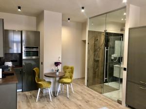a kitchen with a table and chairs and a shower at Silver Dawn Apartments in Szeged