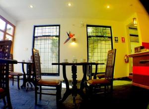 a dining room with a table and chairs and windows at Illas Inn in Cusco
