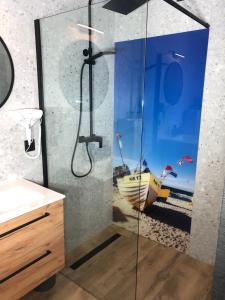 a bathroom with a shower with a view of a boat at Karwia Marina Apartamenty in Karwia