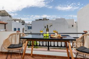 a balcony with a table with wine glasses and chairs at Kallisti Studios in Naxos Chora