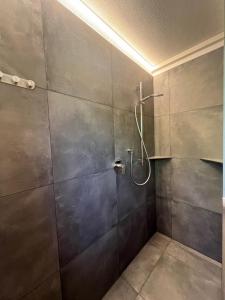 a bathroom with a shower with a glass door at M&M Apartment in Perca