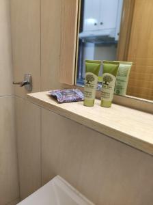 Un mostrador de baño con dos productos en un alféizar de la ventana en Hotel Ritsa en Kamena Vourla
