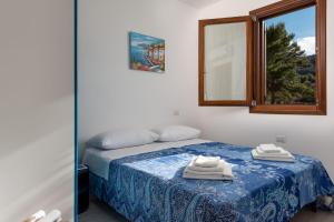 a bedroom with a bed with a mirror and a window at Le case di San Vito in San Vito lo Capo