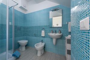 サン・ヴィート・ロ・カーポにあるLe case di San Vitoの青いタイル張りのバスルーム(トイレ、シンク付)
