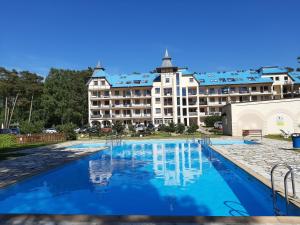 a large hotel with a pool in front of a building at Apartament Marinero in Łukęcin