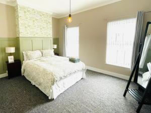 a bedroom with a white bed and a window at Calla's place in Derry Londonderry